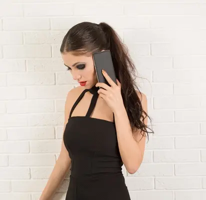 Femme au téléphone illustrant le service de conversation confidentielle Duo Convivial, un échange discret et convivial.